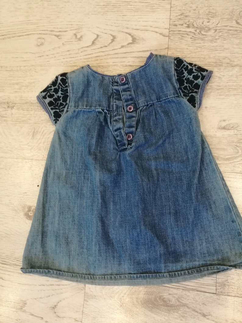 at the front with wrinkles,healthy with botton closure on the back embroidery with small sleeves about 1 year Denim dress little girl