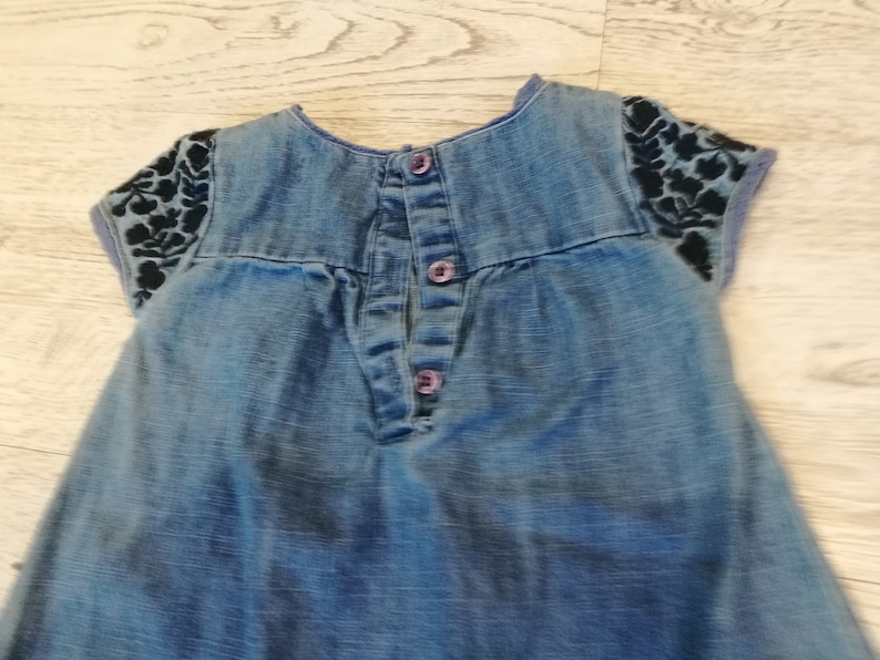 at the front with wrinkles,healthy with botton closure on the back embroidery with small sleeves about 1 year Denim dress little girl