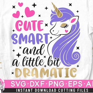 May include: A white t-shirt with a purple unicorn and the text "Cute Smart and a little bit Dramatic". The unicorn has a gold horn and pink hearts around it.
