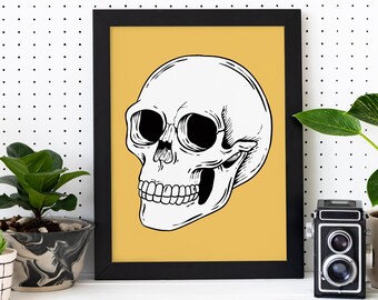 Puede incluir: Una impresión enmarcada en negro con un fondo amarillo que presenta un dibujo de línea de una calavera blanca con ojos negros y una sonrisa de dientes.