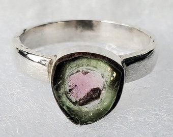 Può includere: Un anello d'argento con una pietra preziosa triangolare verde e rosa.