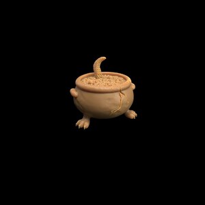 May include: A brown ceramic cauldron with a cracked surface and four legs. The cauldron is filled with a brown liquid and a small, curled, brown object is sticking out of the liquid.