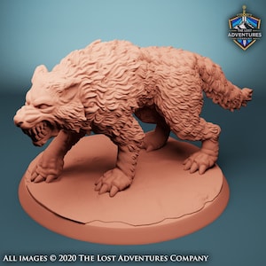 May include: A light brown figurine of a snarling wolf with detailed fur and exposed teeth, on a circular base. The figure is from The Lost Adventures Company.