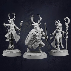 May include: Three grey fantasy figurines of humanoid creatures with deer-like antlers. One figure holds a staff, another a sword and shield, and the third a staff. Each figure is on a circular base.