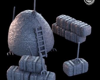 May include: A gray, textured hay bale with a ladder on the side. There are several smaller hay bales stacked on the ground, and a pitchfork is leaning against one of the bales.