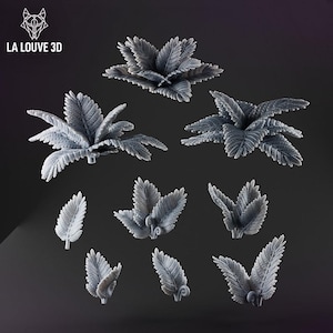 May include: A selection of grey, 3D-printed fern leaves and clusters. The leaves have detailed veining and a textured surface. The image includes the text "LA LOUVE 3D" and a logo in the upper left corner. The leaves vary in size and shape.