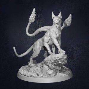 May include: A detailed, grey sculpture of a feline creature with large, curved appendages and a snarling expression. The figure is posed atop a rock formation, showcasing intricate details and musculature. The base is a simple, circular platform.