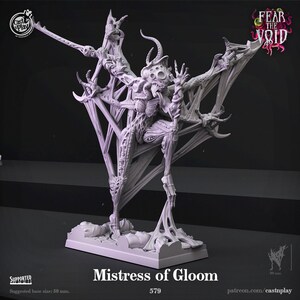 May include: A grey 3D printed miniature of a monstrous creature with multiple limbs and a grotesque face. The creature is standing on a base with a web-like design. The text "Mistress of Gloom" and "579" are printed below the base. The text "FEAR THE VOID" is printed in the top right corner of the image.