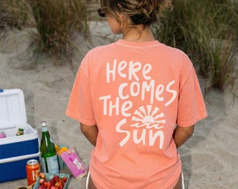 Camiseta «Here Comes The Sun», estampado veraniego, camiseta de playa, vacaciones, sol, atuendo costero.