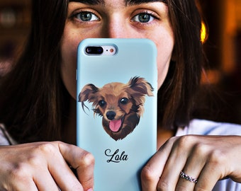 May include: A light blue phone case with a cartoon illustration of a brown and white dog with a pink tongue sticking out. The dog's name, "Lola", is written in black cursive below the image.