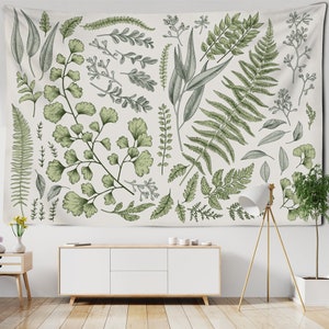 Op de afbeelding: Een wandkleed met een botanische print van verschillende groene bladeren en varens op een witte achtergrond.