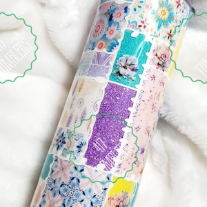 May include: A floral patchwork tumbler with a stainless steel lid. The design features various floral patterns, glitter, and the text "417 Tumblers" in a green wavy border. The tumbler is cylindrical and appears to be insulated.