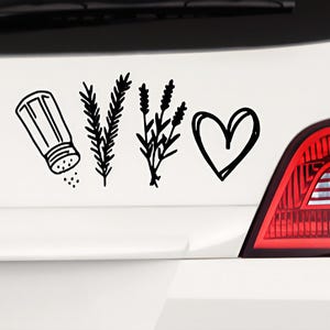 May include: Black and white line art sticker featuring a salt shaker, sprigs of rosemary and lavender, and a heart. The sticker is applied to a white surface, with a red taillight visible in the background. The design suggests a culinary or home decor theme.
