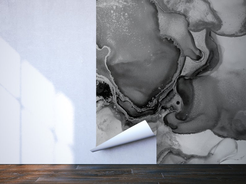 May include: A close-up of a black and white abstract wallpaper being applied to a white wall. The wallpaper has a marbled, fluid design.
