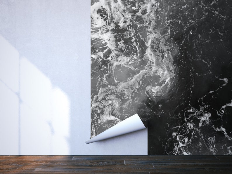 May include: A partially installed wallpaper with a black and white marble design. The wallpaper is peeling away from the wall, revealing a white surface. The floor is made of dark wood.