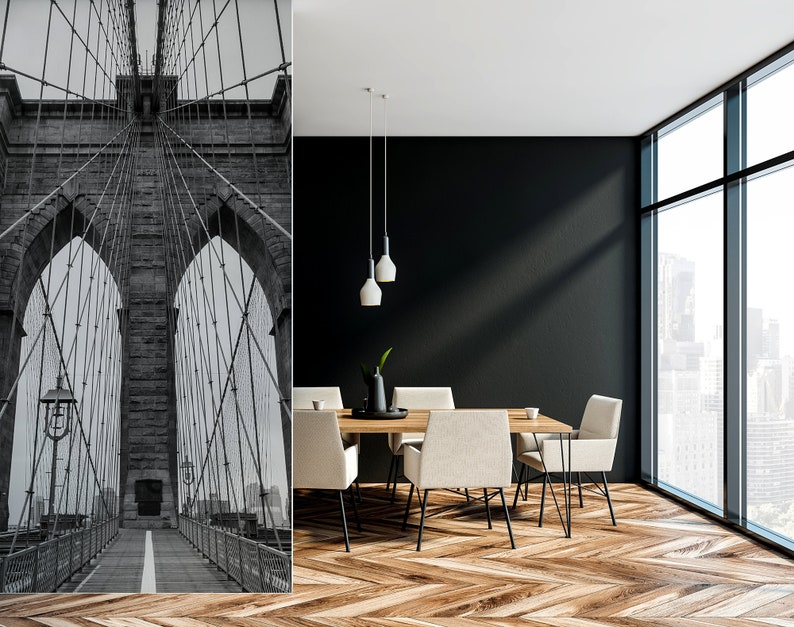 May include: Black and white photo of the Brooklyn Bridge in New York City. The photo is used as a wall mural in a modern dining room with a wooden table and chairs.