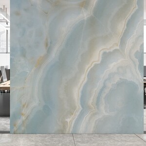 May include: A light blue and white marble wall with a swirling pattern. The wall is in a modern office setting with glass walls and a desk with chairs.