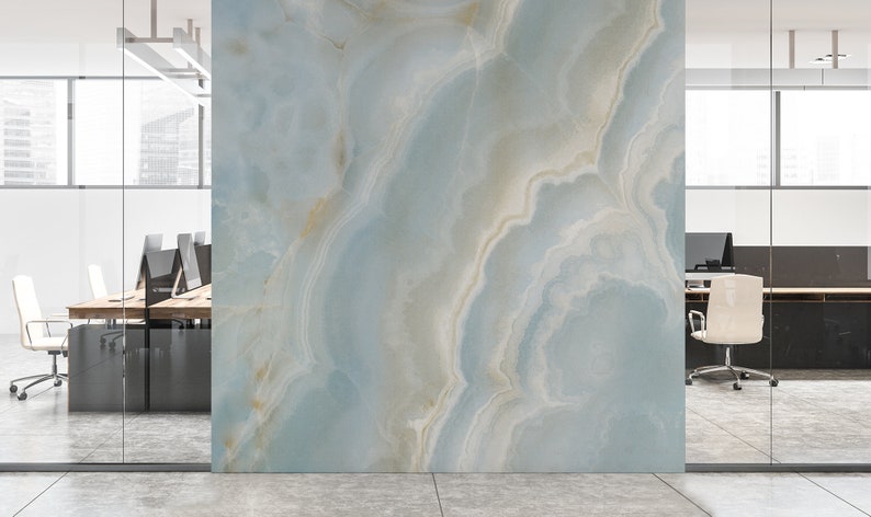 May include: A light blue and white marble wall with a swirling pattern. The wall is in a modern office setting with glass walls and a desk with chairs.