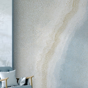 May include: A light blue and beige abstract wall mural with a textured, marbled effect. The mural features a light blue and beige color scheme with a subtle, swirling pattern.