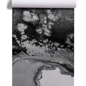 May include: Abstract black and silver glitter art print. The print features a swirling design with silver glitter accents on a black background.