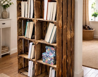 May include: A rustic wooden bookshelf made from repurposed crates, filled with books and decorative boxes. The bookshelf is stained a warm brown and features multiple shelves. A potted plant sits on top, adding a touch of greenery to the space.