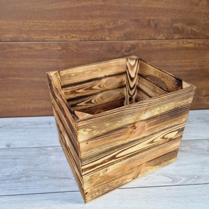 May include: A rustic wooden box with a natural wood finish. The box is made of reclaimed wood and has a distressed look. It is perfect for storing small items or for use as a decorative piece.