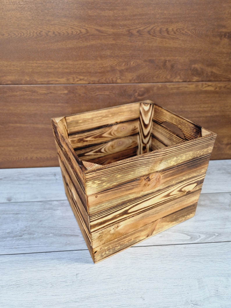 May include: A rustic wooden box with a natural wood finish. The box is made of reclaimed wood and has a distressed look. It is perfect for storing small items or for use as a decorative piece.