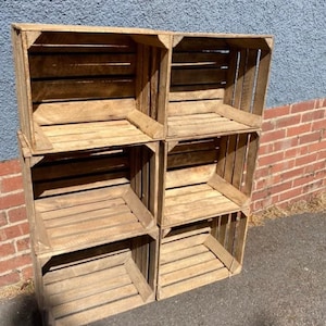 May include: A set of six wooden crates stacked to create a shelving unit. The crates are made of natural wood and have a rustic appearance.
