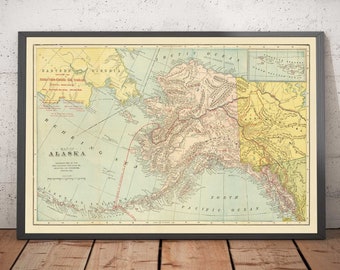 May include: A vintage map of Alaska, printed in yellow, green, and brown, with the text "Map of Alaska" in the center. The map shows the state's geography, including mountains, rivers, and coastlines. The map is framed in a black frame.