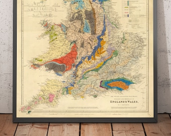 May include: A vintage geological map of England and Wales, showing the different rock formations in various colors. The map is framed in a black frame and has a title at the bottom: "The Geological Map of England & Wales."