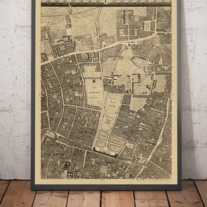 Puede incluir: Un mapa antiguo de Londres, Inglaterra, impreso en blanco y negro sobre papel crema. El mapa muestra las calles, edificios y monumentos de la ciudad, incluyendo la Torre de Londres, la Catedral de San Pablo y el Palacio de Buckingham.