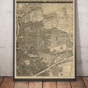 Puede incluir: Un mapa antiguo de Whitechapel, Londres, Inglaterra. El mapa está impreso en blanco y negro sobre papel crema. El mapa muestra las calles y los edificios de la zona. El mapa está enmarcado en un marco negro.