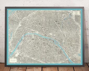 Può includere: Una mappa vintage di Parigi, Francia, stampata in bianco e nero con accenti blu. La mappa mostra le strade della città, i monumenti e la Senna.