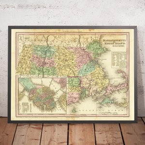 Pode incluir: Mapa vintage emoldurado de Massachusetts e Rhode Island, com cartografia detalhada em cores pastel. O mapa inclui texto como "Tanner's Universal Atlas" e "Massachusetts Rhode Island". A moldura é preta, sobre uma superfície de madeira.