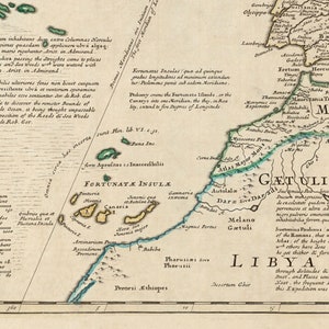 May include: An antique map of North Africa, showing the coastline of the Mediterranean Sea and the Atlas Mountains. The map is in shades of green, blue, and brown, with text in black and red. The map is titled "Getulia ubi G&aelig;tuli habitant" and includes the text "Fortunate Insul&aelig;" and "Libya Interior".