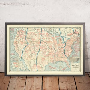 May include: A vintage map of the United States showing the different time zones. The map is printed on cream-colored paper with red and blue lines and text. The map is titled "Commercial Map of the United States".
