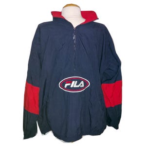 Pu&ograve; includere: Giacca Fila blu navy e rossa. La giacca presenta un colletto rosso e pannelli rossi sulle maniche. Il logo Fila &egrave; ricamato sul davanti. Presenta una chiusura a mezza zip.