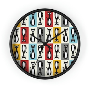 May include: A round wall clock with a black frame. The clock face features a repeating pattern of black cat silhouettes on a colorful checkered background of red, yellow, blue, gray, and cream. The clock hands are black.