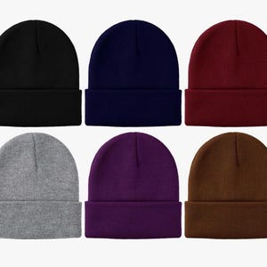 May include: Six different colored knit beanies. The beanies are all the same style, with a fold-over cuff. The colors are black, navy blue, burgundy, gray, purple, and brown.