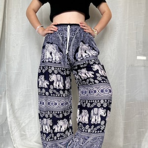 May include: Blue and white patterned pants with an elephant design. The pants have a drawstring waist and are loose fitting.