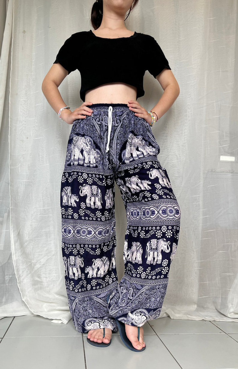 May include: Blue and white patterned pants with an elephant design. The pants have a drawstring waist and are loose fitting.