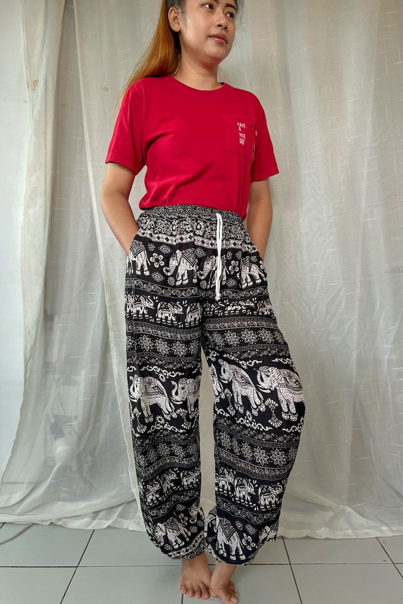 May include: Black and white patterned pants with an elephant design. The pants have an elastic waistband and a drawstring.