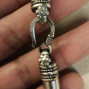 Pu&ograve; includere: Braccialetto in argento con un design floreale dettagliato e una chiusura a gancio.