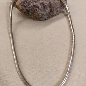 Pu&ograve; includere: Una collana a catena di serpente d'argento con chiusura a moschettone.