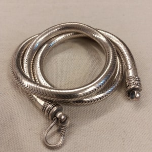 Pu&ograve; includere: Una collana a catena di serpente d'argento con chiusura. La catena &egrave; realizzata con piccoli anelli intrecciati che creano un aspetto liscio e fluido.