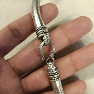 Pu&ograve; includere: Collana a catena di serpente in argento con una chiusura decorativa. La catena &egrave; realizzata con piccoli anelli intrecciati che ricordano le squame di un serpente.