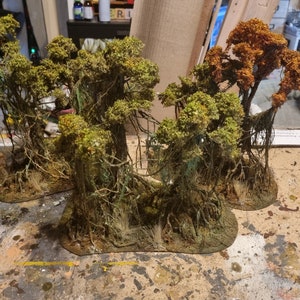 May include: Miniature swamp trees with green and orange foliage, detailed with hanging roots and textured bases. These handcrafted trees are designed for tabletop gaming or model scenery, adding a realistic touch to any diorama or game board.