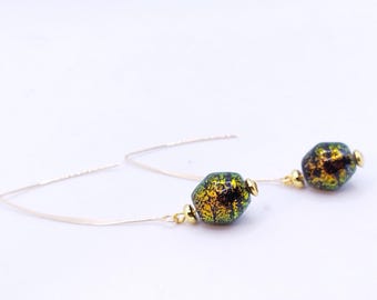 May include: A pair of gold dangle earrings with green and gold glass beads. The beads have a speckled, iridescent finish.