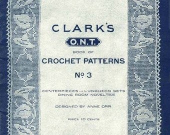 May include: A vintage blue and white crochet pattern book cover with the title "CLARK'S O.N.T. BOOK OF CROCHET PATTERNS No. 3" and the text "CENTERPIECES - LUNCHEON SETS DINING ROOM NOVELTIES DESIGNED BY ANNE ORR PRICE 10 CENTS".