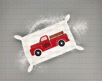 May include: A white fabric dish towel with a red truck design. The truck has a wooden bed and the words "The Farm" printed on the side.